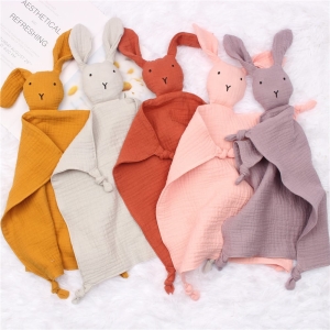 Fem kaniner i olika färger på ett ljusfärgat tyg