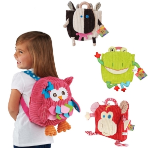 En flicka med en rosa plyschryggsäck med uggla och tre andra plyschryggsäckar med en ko, en groda och en röd apa