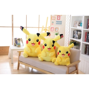 tre pikachus i olika storlekar sitter på en beige soffa i ett vackert rum