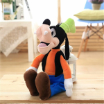 Plysch av Disney-figuren som sitter på ett parkettgolv, han har blå byxor och en orange topp