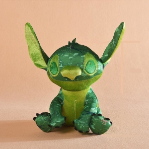 Stitch, Disney-tecknad hjälte, är en mörkgrön plysch med ljusgröna öron och mage och sitter med öronen upplysta