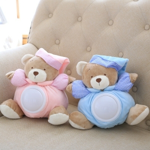 Musikalisk nallebjörn vitt brus med en blåklädd och en rosa klädd som sitter i en beige soffa